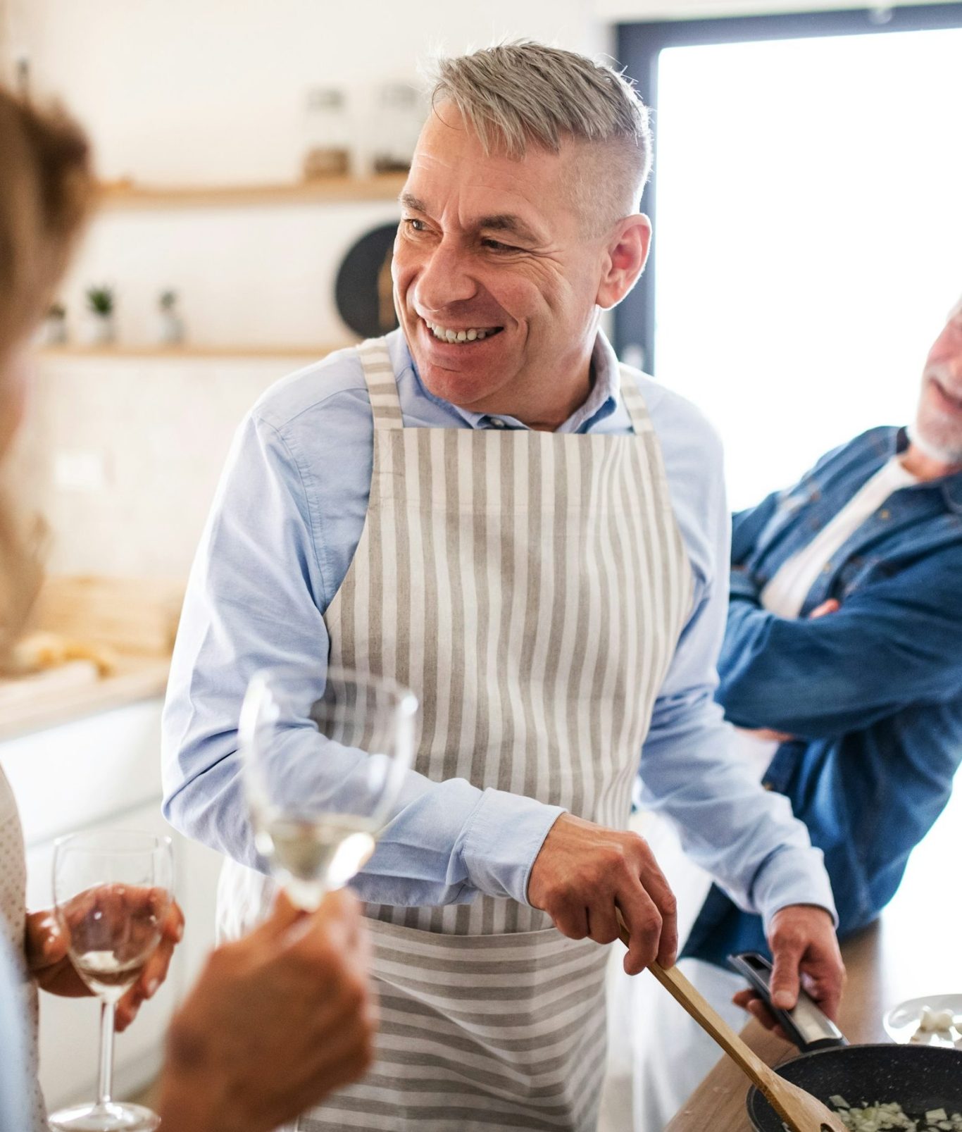 Mann kocht mit Freunden und haben Spaß in der Küche 