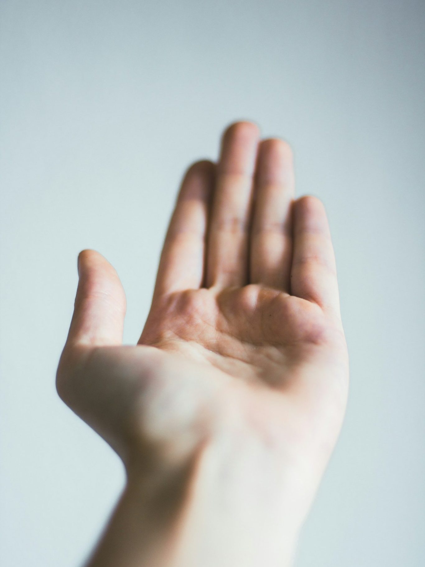 Hand mit Handfläche nach oben, Hand ist im Fokus der Kamera