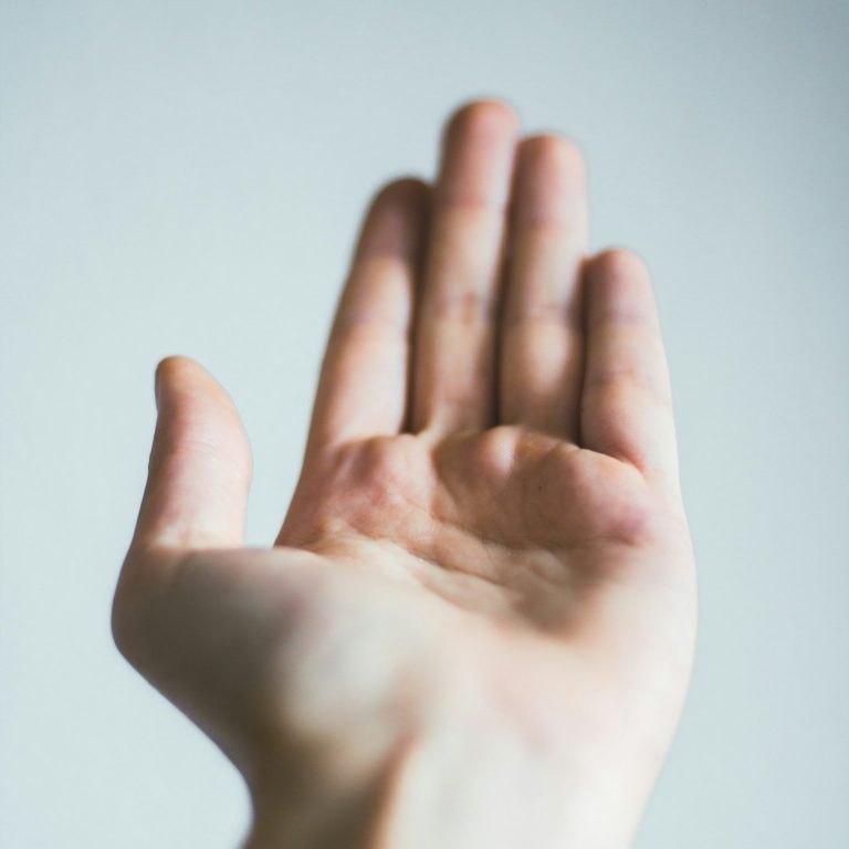 Hand mit Handfläche nach oben im Fokus der Kamera